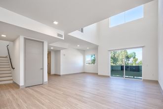 a living room with white walls and a door to a pool