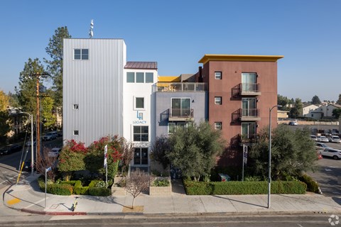 A building with a red roof and a white building with a yellow roof are next to each other.