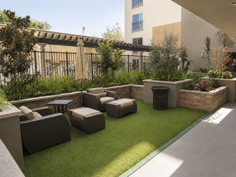 A patio with a couch, chairs, and a table.