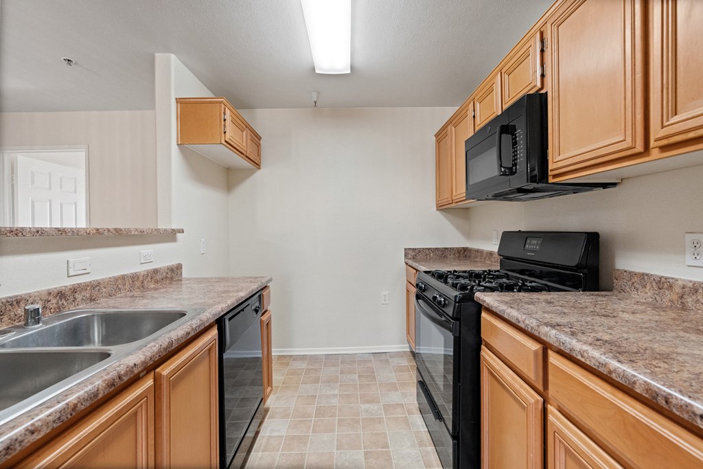 a kitchen with granite counter tops and a black stove and microwave