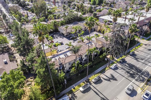 A street view of a residential area with houses and parked cars.