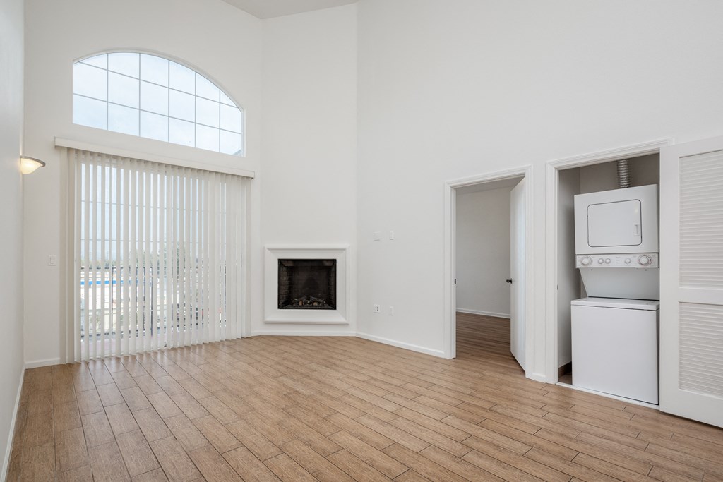 an empty living room with a fireplace and a window