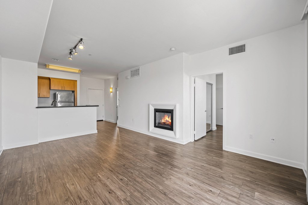 a living room with a fireplace and a kitchen
