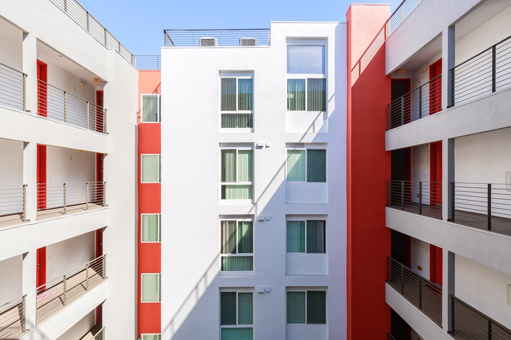 a row of apartment buildings with red and white balconies