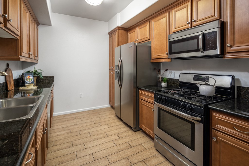 a kitchen with stainless steel appliances and wooden cabinets