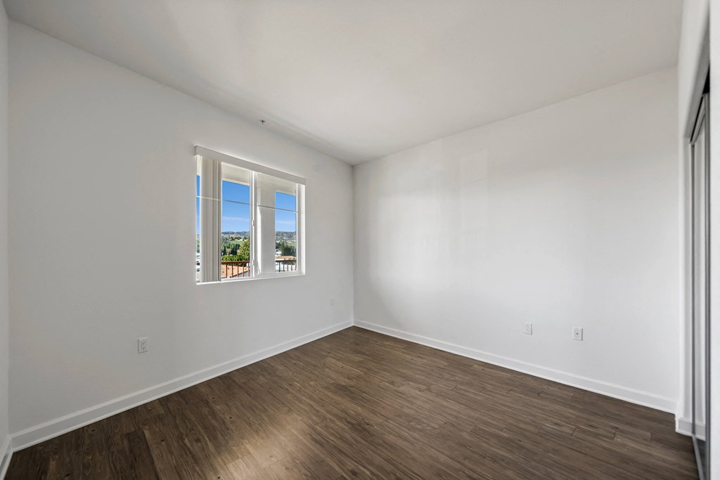 an empty room with white walls and a window