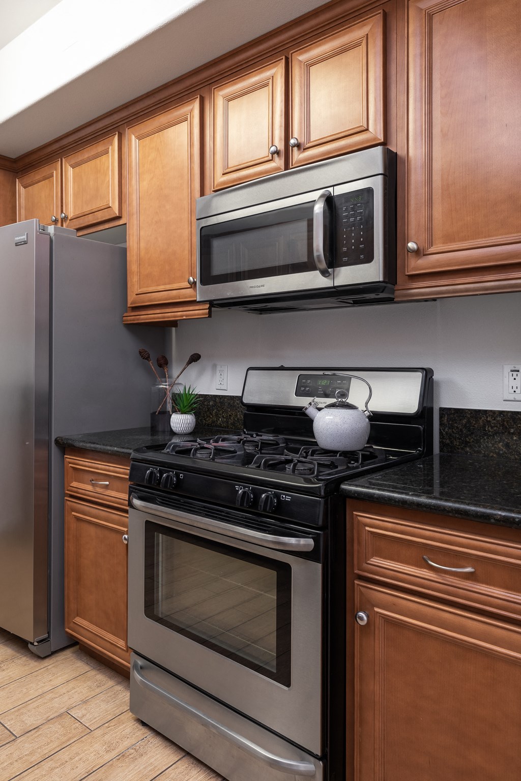 a kitchen with stainless steel appliances and wooden cabinets