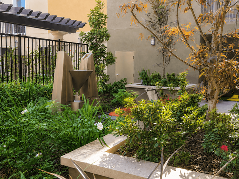 A garden with a bench and a sculpture.