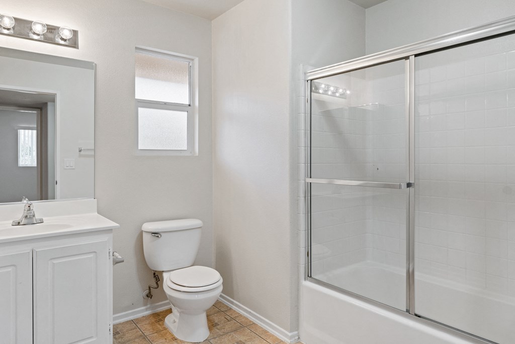 an empty bathroom with a shower toilet and sink