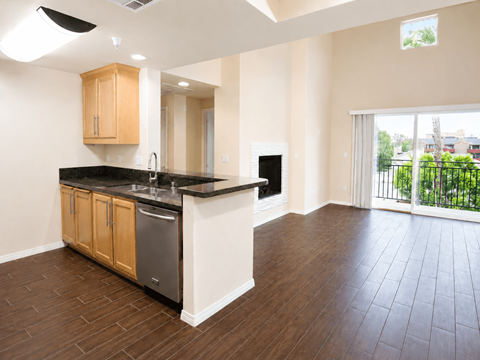 A kitchen with wooden cabinets and black countertops.