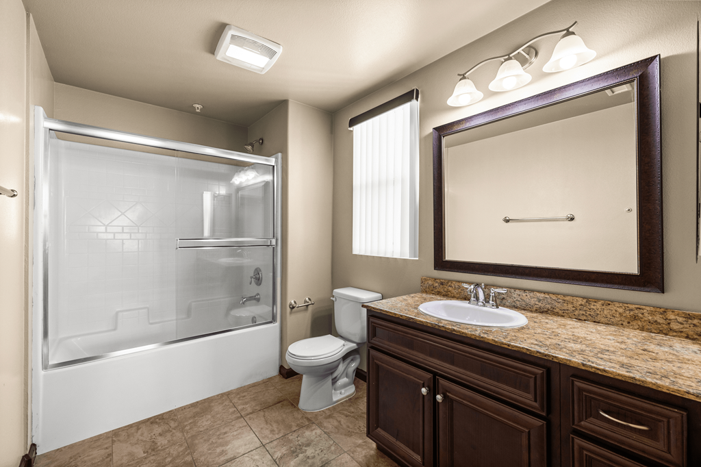 a bathroom with a shower toilet and sink and a mirror at Le Blanc Apartment Homes, California