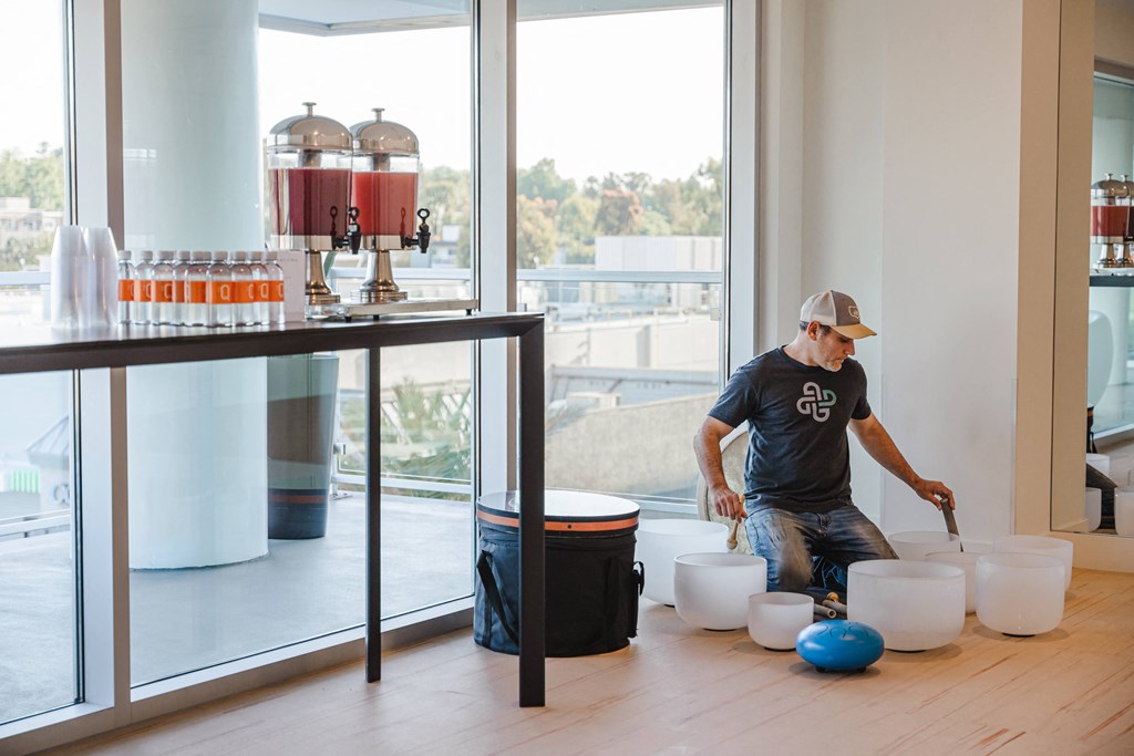 a man in a blue shirt and a white hat is kneeling on a wooden floor and is