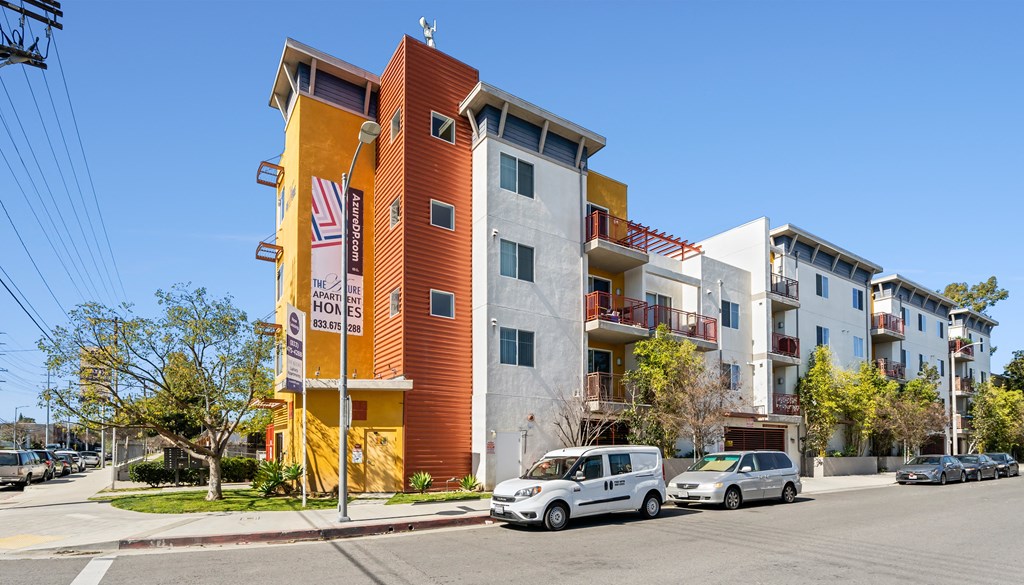 a new apartment building with cars parked in front of it