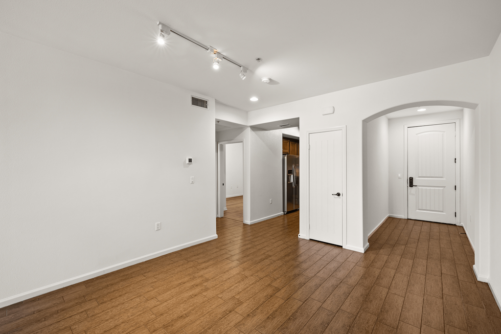 a living room with wood floors and white walls and white doors at Le Blanc Apartment Homes, Canoga Park, CA