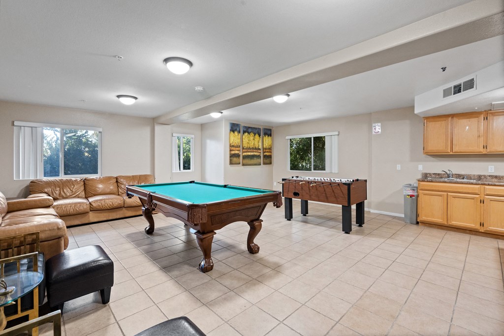 a game room with a pool table and two billiards
