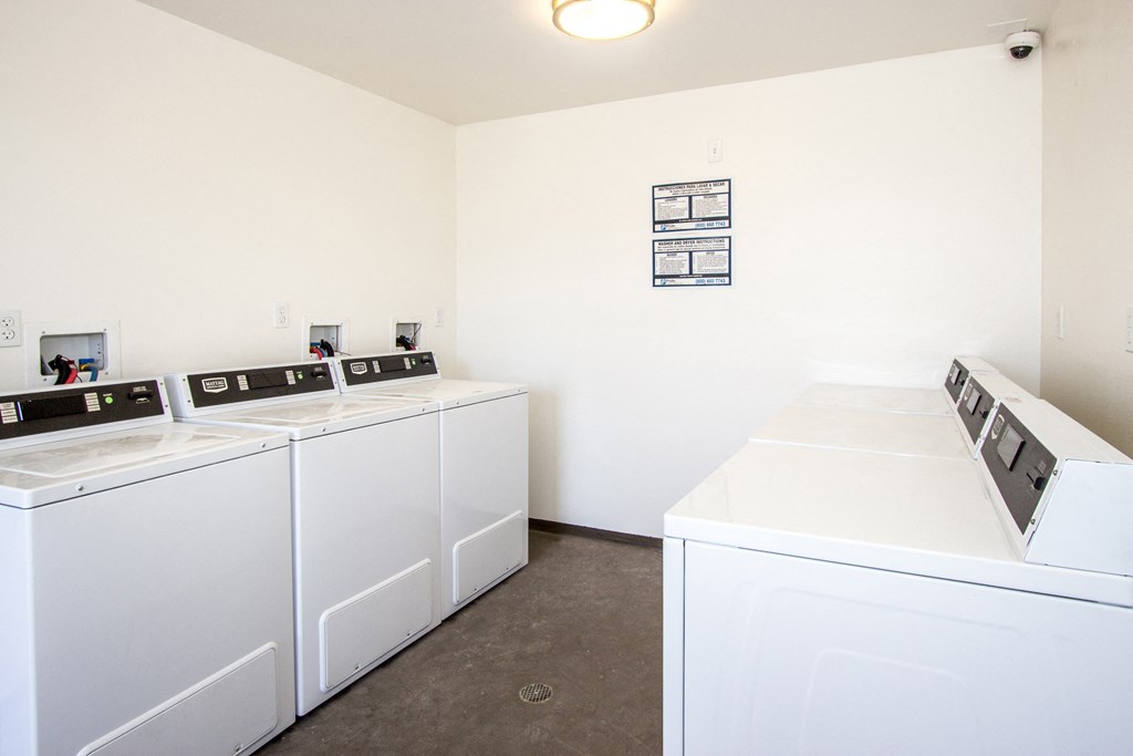 a laundry room with four washers and dryers in it