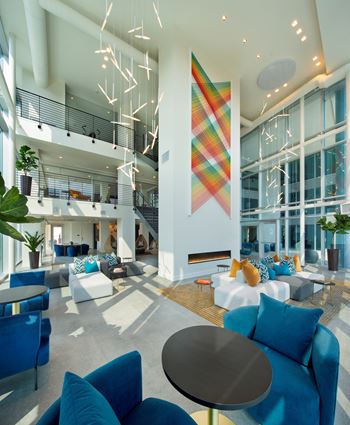 the lobby of an office building with blue couches and chairs