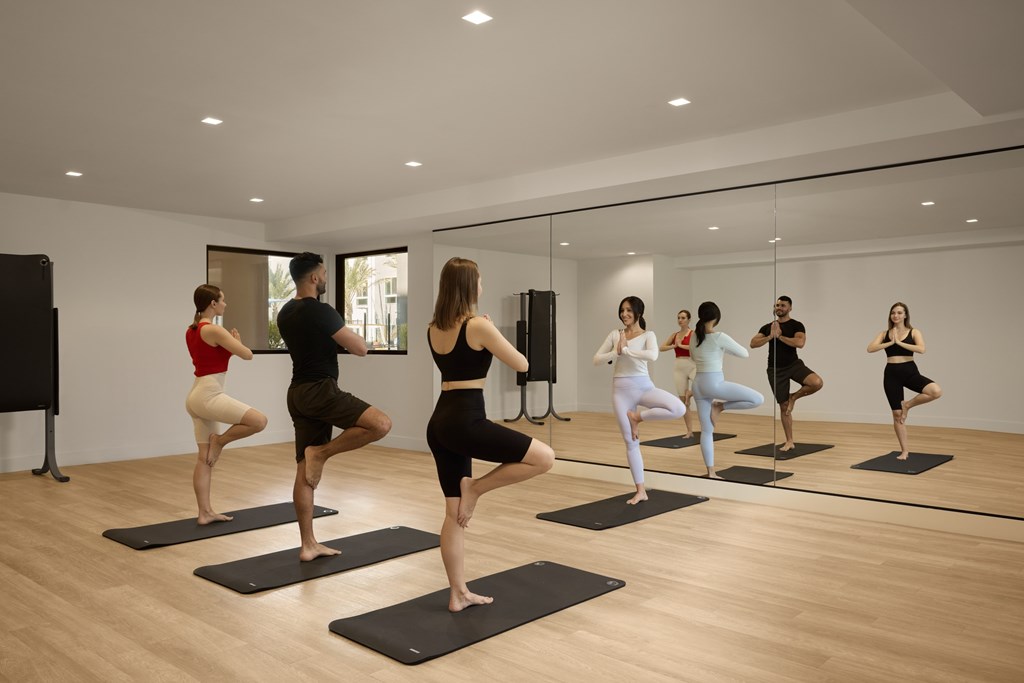 A group of people practicing yoga in a studio.