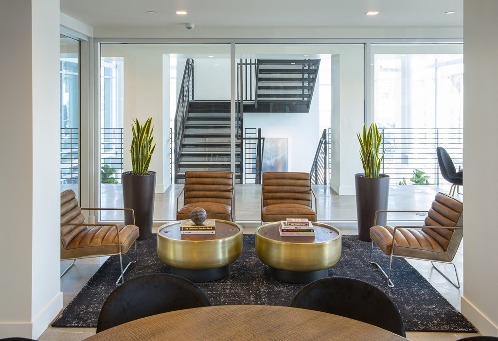 a lobby with chairs and tables and a staircase
