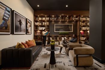 A man is sitting on a couch in a room with a coffee table in front of him.