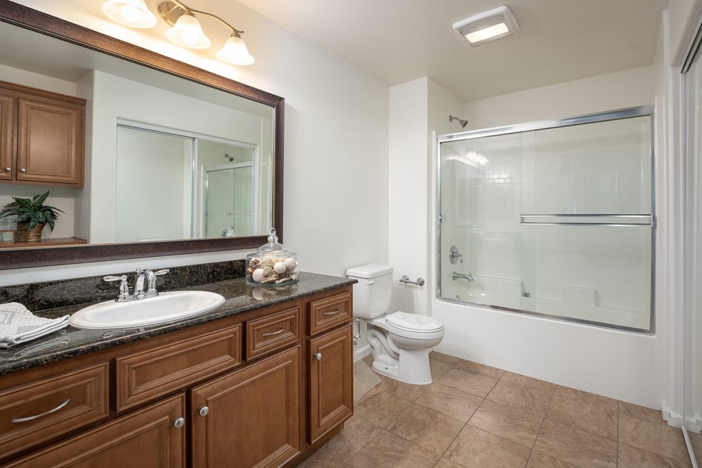 a bathroom with a large mirror and a toilet and a shower