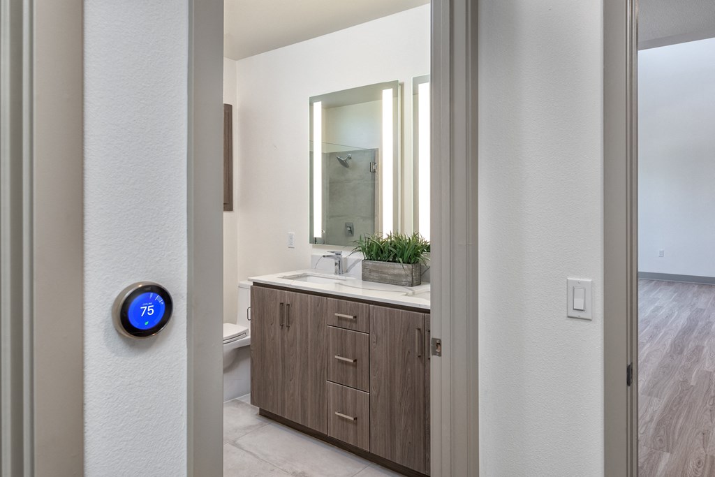 an open door leading to a bathroom with a mirror and a sink