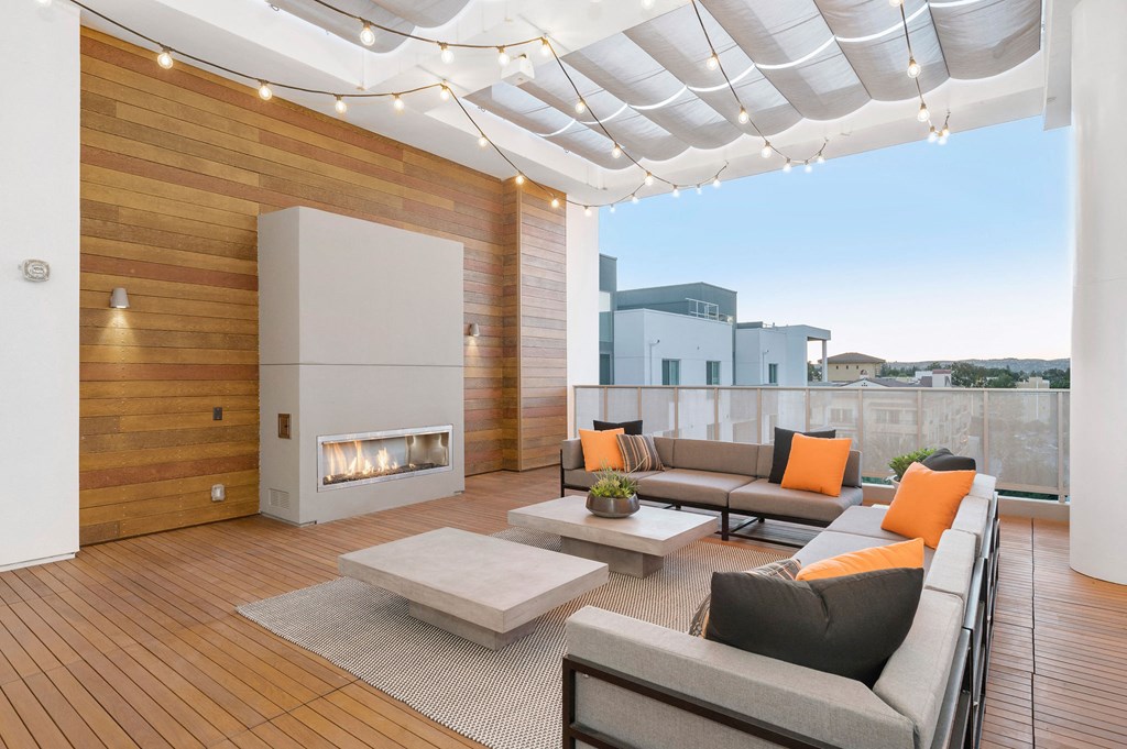 a living room with couches and a fireplace on a balcony
