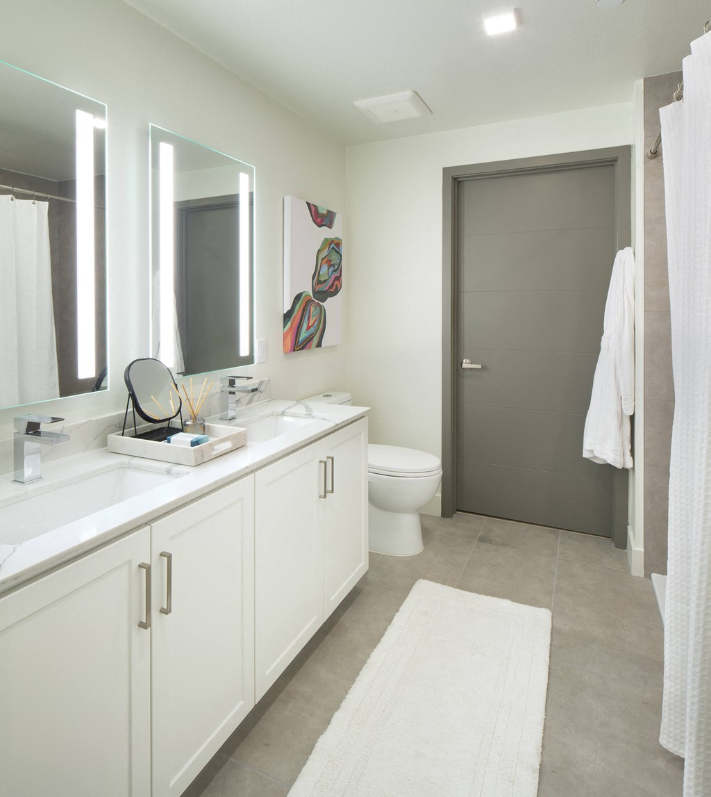 a white bathroom with two sinks and a toilet