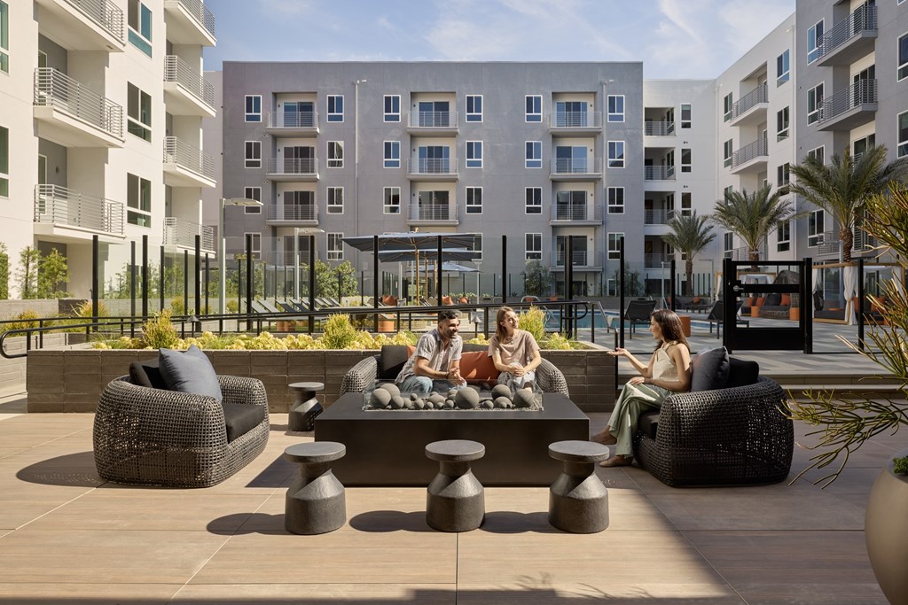A group of people are sitting on a couch and chairs on a patio.