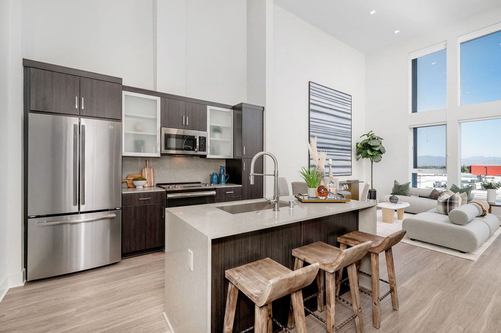 a kitchen with stainless steel appliances and a island with three stools