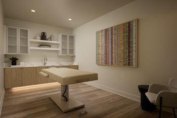 A room with a massage table and a chair.