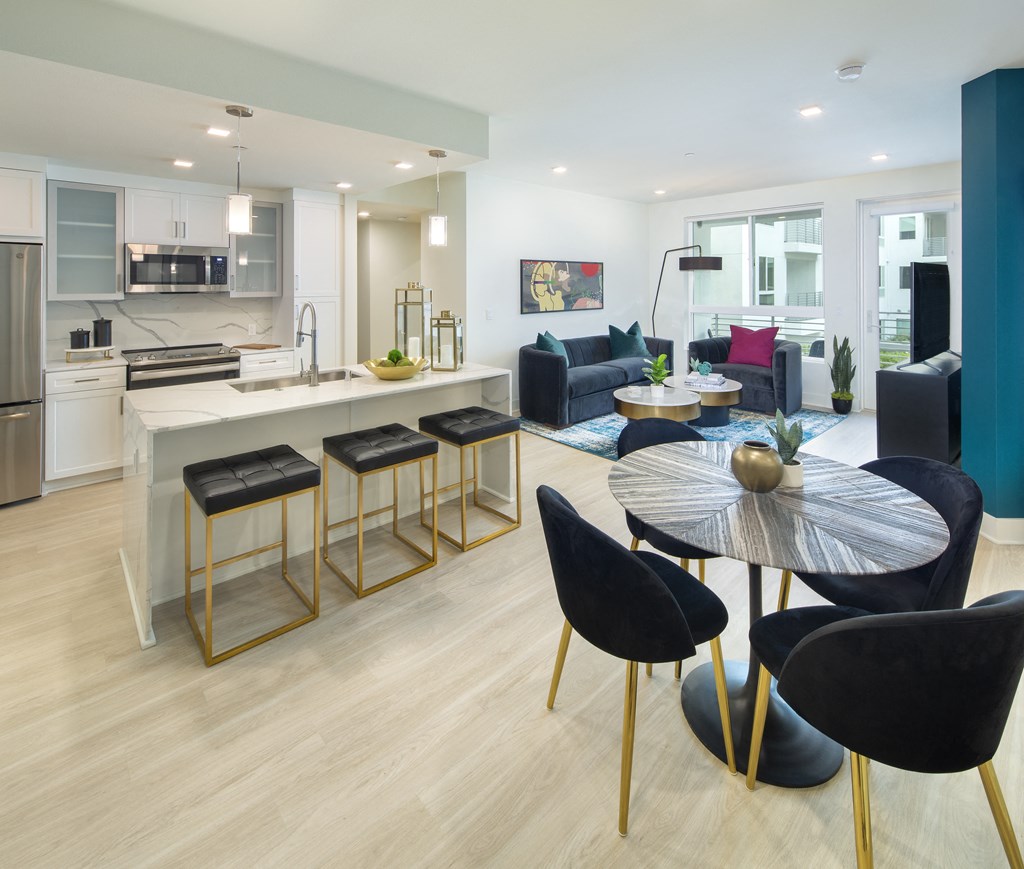 a living room and kitchen with a table and chairs