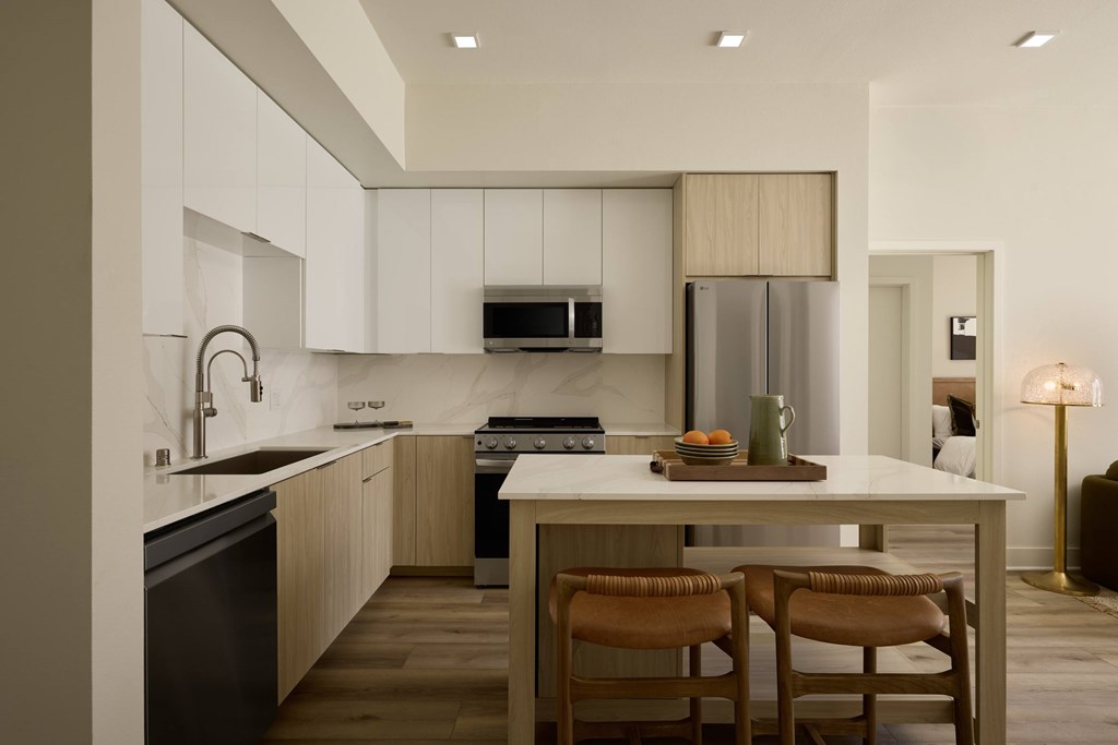 A modern kitchen with a dining table and chairs.