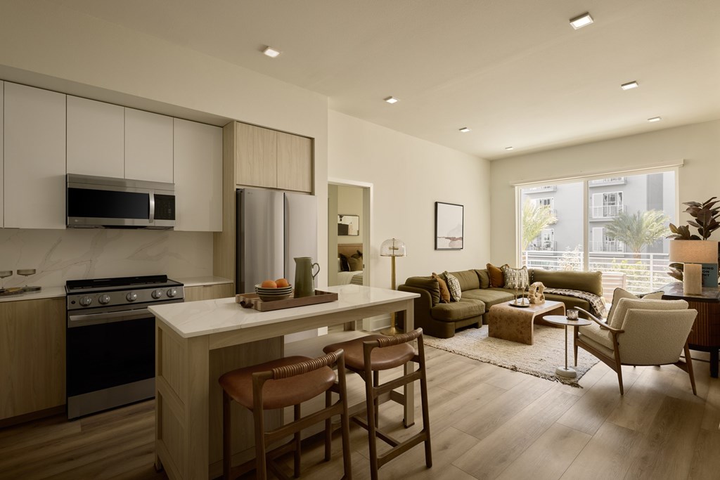 A modern kitchen with a dining area and a living room.