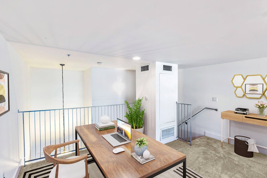 a living room with a wooden table and a railing