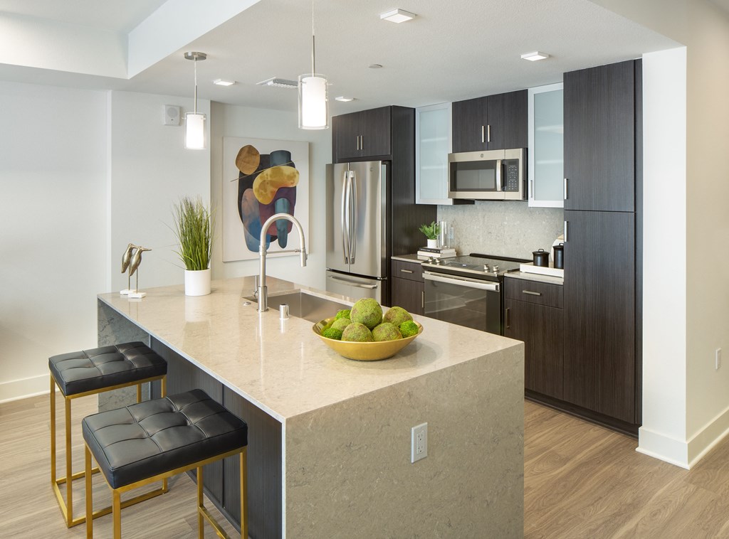 a kitchen with a large island with a bowl of fruit