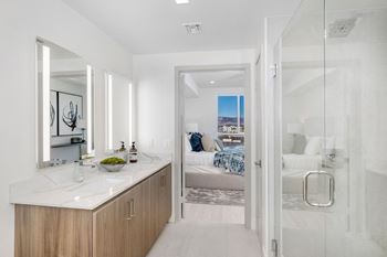 a bathroom with a shower and a sink and a bedroom