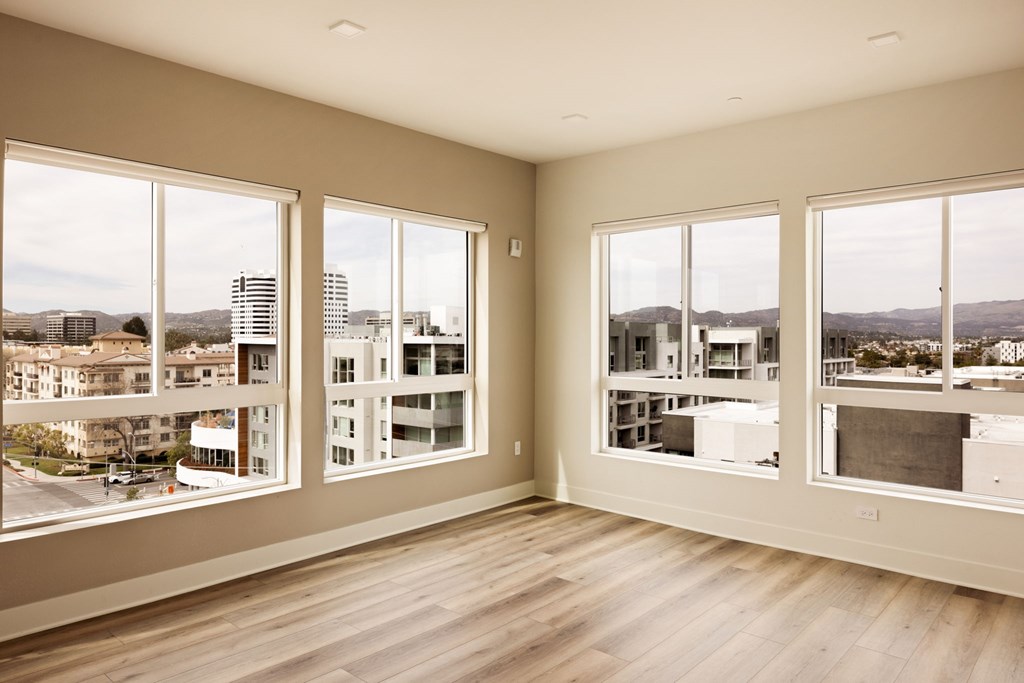 A room with large windows overlooking a cityscape.