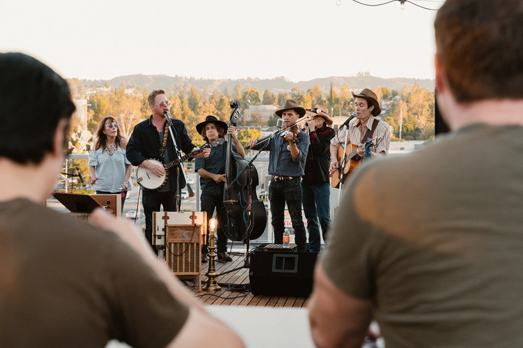 a group of musicians playing instruments on a stage with people watching