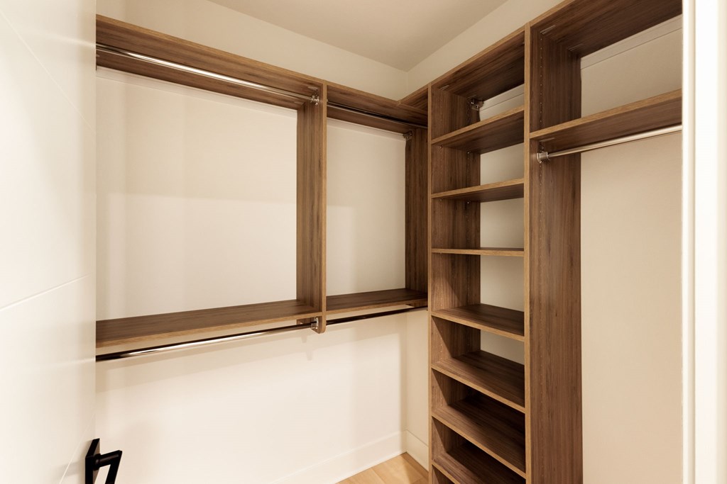 A wooden shelving unit with glass doors is mounted on a white wall.