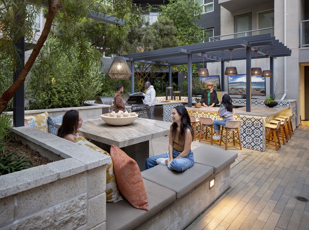 a group of people sitting on benches in an outdoor patio