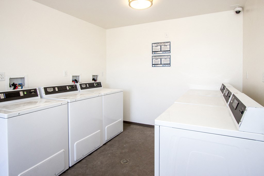 a laundry room with four washers and dryers in it