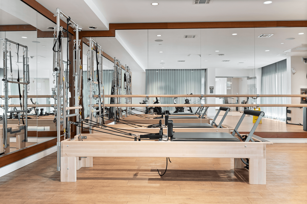 a row of weights machines in a room with mirrors