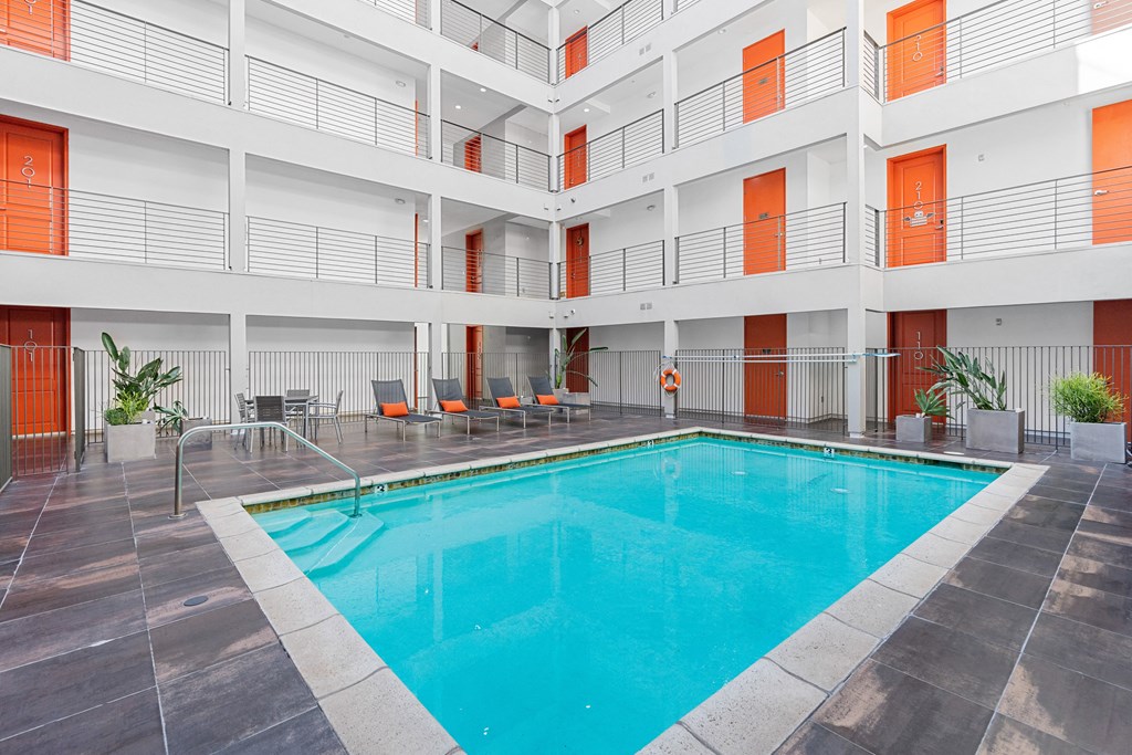 the pool of a hotel with chairs and a swimming pool