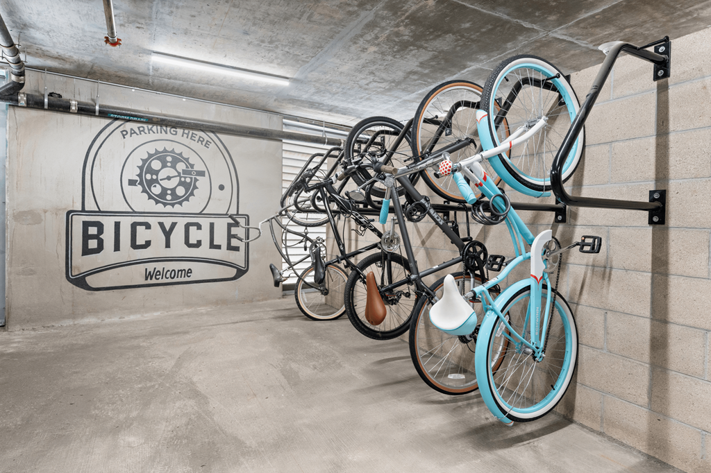 a group of bikes hanging on a wall in a bike garage