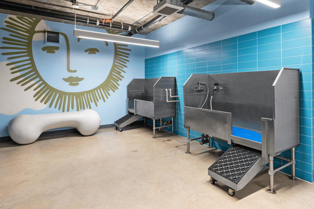 a room with two refrigerators and a mural of a woman on the wall