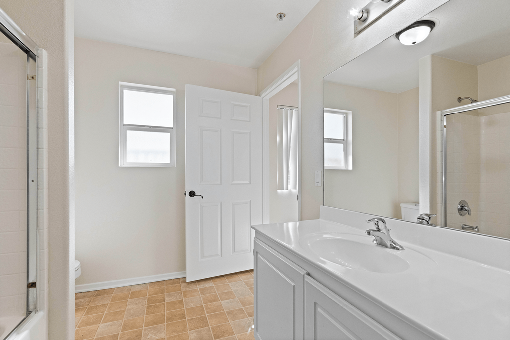 A bathroom with a white sink and a white door.