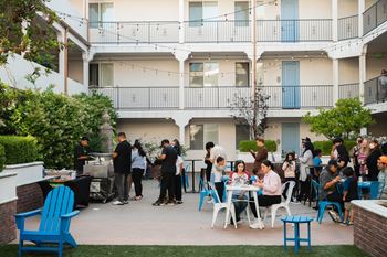 a group of people sitting at tables on a patio outside of a building