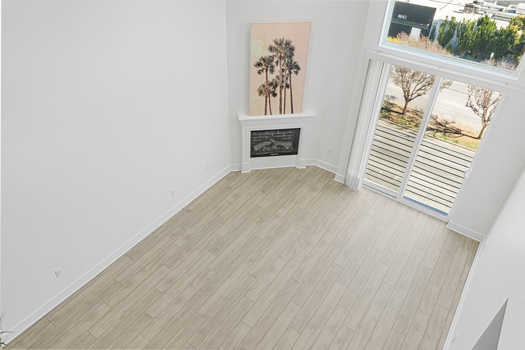 an empty living room with a wood floor and a fireplace