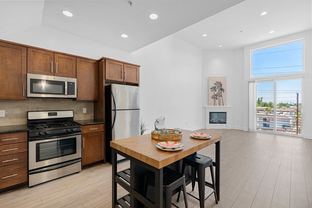 a kitchen with wooden cabinets and stainless steel appliances and a wooden table